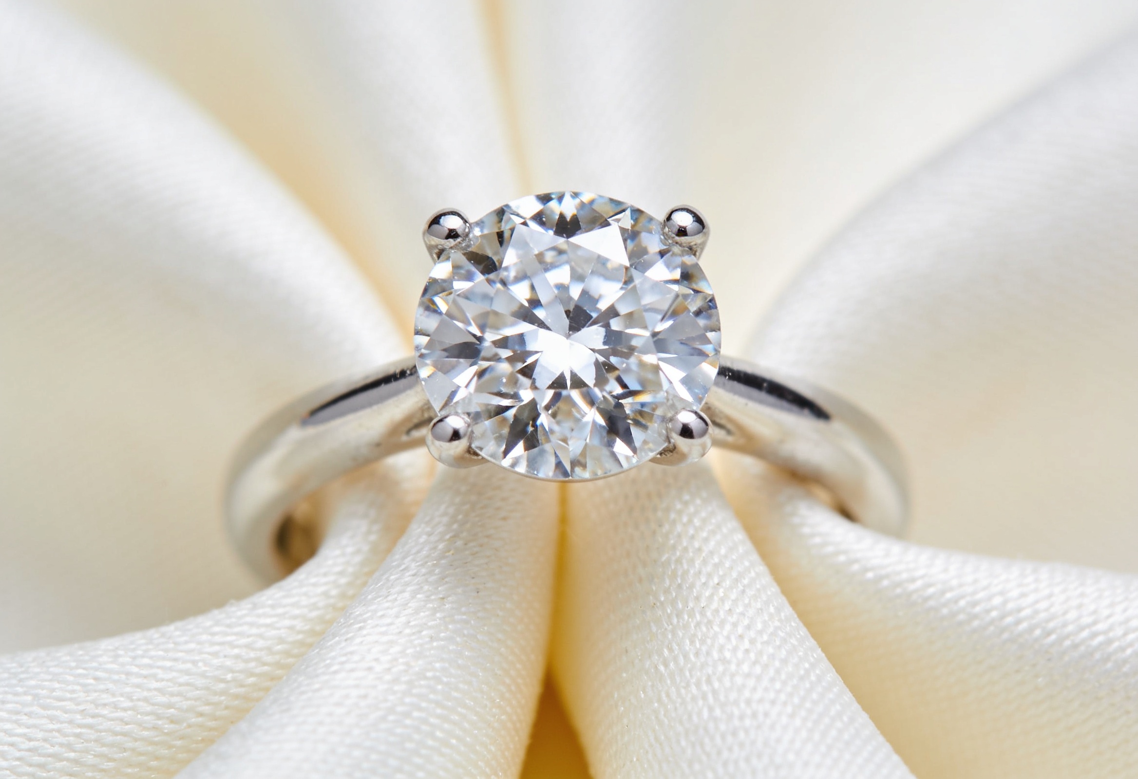 How to Clean a Diamond Ring 3 Sparkling clean diamond solitaire engagement ring on a cream cloth