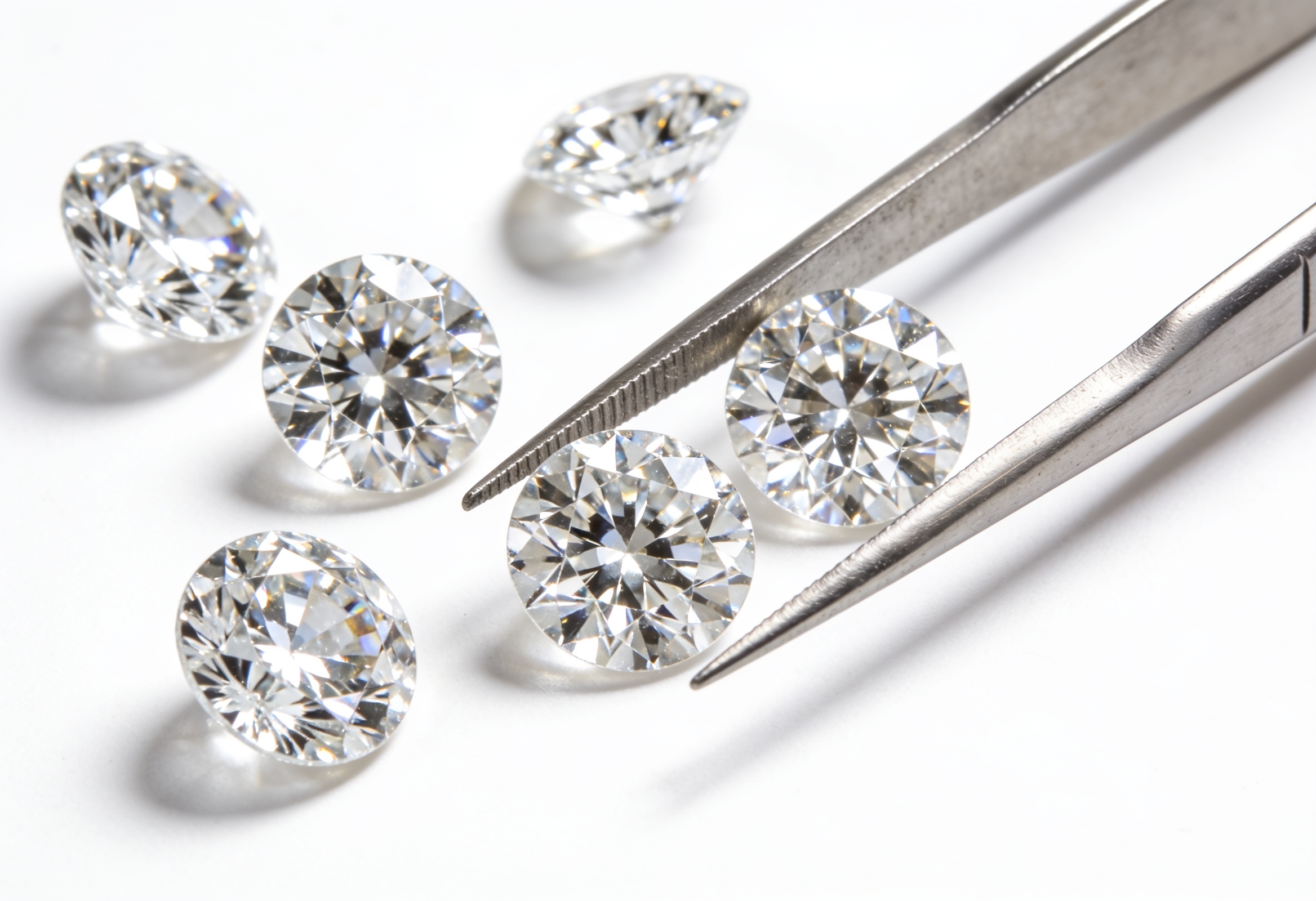 Lab Grown Diamond Earrings in Canada 2 Loose matched round brilliant lab grown diamonds beside jeweler's tweezers